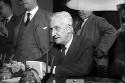 Il Presidente argentino Arturo Umberto Illia seduto, parlando in pubblico.