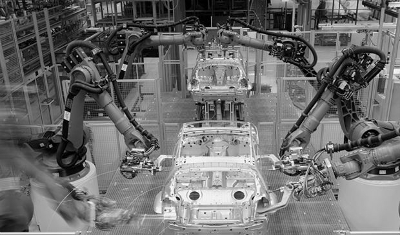 Robots en una fàbrica de cotxes. Robots en una fàbrica de cotxes.