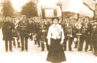 Dona amb bandera al capdavant d'una desfilada.